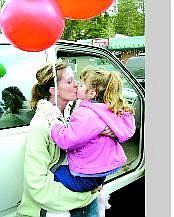 Susan Rizk kisses her daughter after returning home following a nearly two-month stay at Washoe  Medical  Center. Rizk was attacked at her South Lake Tahoe home by a man wielding a sword.  Jim Grant/Appeal News Service