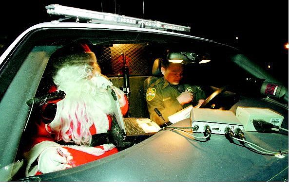 BRAD HORN/Nevada Appeal Carson City Sheriff&#039;s reserve deputy Homer Dagdagen and Santa Claus get ready to bring gifts and Christmas cheer to a Carson City family on Christmas Eve.