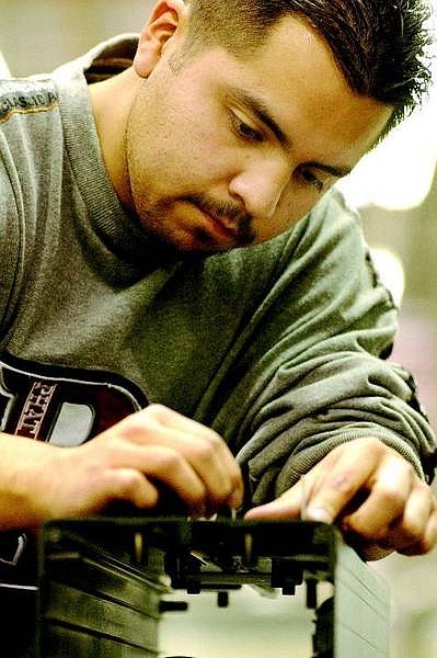 Kevin Clifford/Nevada Appeal Production worker Marco Galvan from Dayton, Nevada concentrates while starting to assemble a speaker unit  at Bohlender Graebener Corporation Tuesday, Dec. 27, 2005 in Carson City.