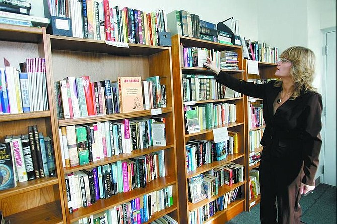 Chad Lundquist/Nevada Appeal Quest Lakes, of the Silver City Volunteer Library, points to some of the books at the library in the firehouse Tuesday. The library will be open to Silver City residents from 2-4 p.m. Sundays, starting Jan. 8.
