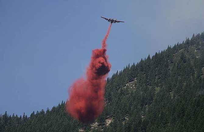 Brad Horn/Nevada AppealA plane drops retardant on the Genoa Peak fire above Genoa on Saturday.