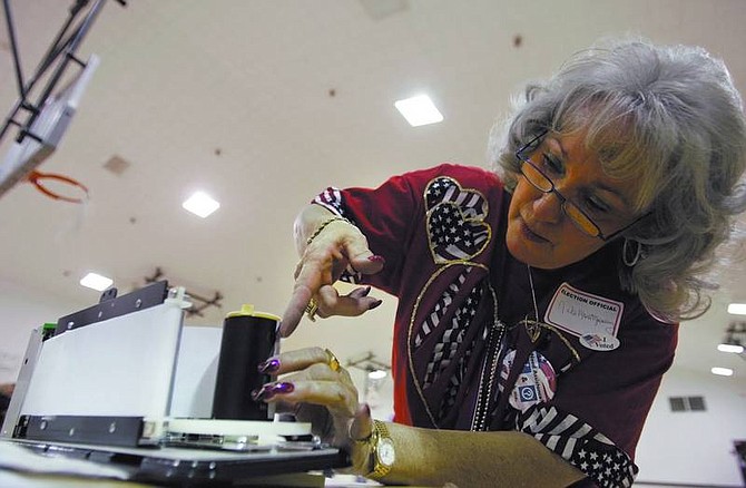 Chad Lundquist/Nevada AppealNita Montgomery works to replaces tape cassettes on one of the 30 voting stations at Dayton High School on Tuesday night.