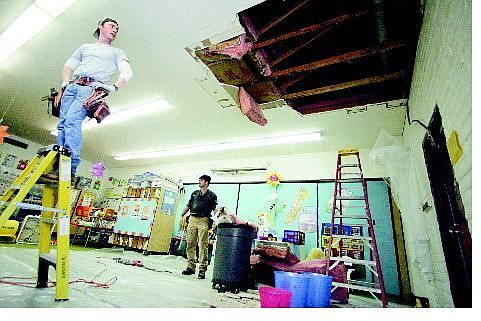 BRAD HORN/Nevada Appeal Jeremy Feeley, left, and Don Kelly of D.G. Hand repair a ceiling in a flood-damaged kindergarten classroom at Seeliger Elementary on Wednesday.