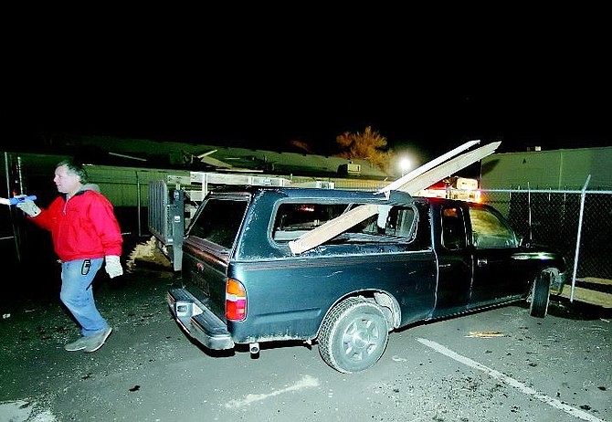 BRAD HORN/Nevada Appeal Tony Villarreal, general manager of Tip Top Amusement Company at 1990 South Roop St., surveys the damage caused from 98 mph winds on Saturday night. Two pieces of wood shot through the side one of the trucks in the company&#039;s yard.