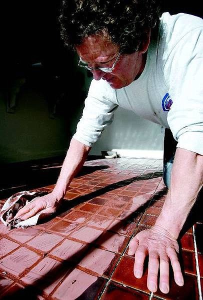 Dave  Rittenhouse polishes the tile to remove the excess grout from the joints and tile surface on Wednesday.  Chad Lundquist/ Nevada Appeal