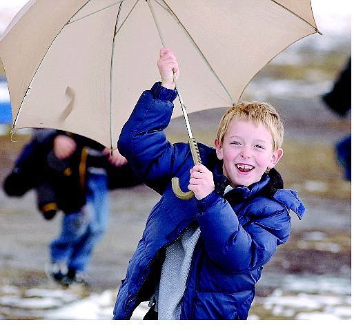 Kevin Clifford/ Nevada Appeal First-grader Henry Wojtowicz, 6, runs with his umbrella during recess at Fremont Elementary School on Tuesday. The National Weather Service issued a winter storm warning until 4 p.m. today.