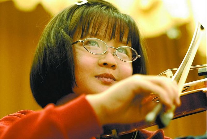 Kevin Clifford/Nevada Appeal Third-grader Nadia Tung, 8 , concentrates as she plays &quot;Salty Dog&quot; during violin practice at Seeliger Elementary School last week. The Strings in Schools after-school program will perform its first concert Thursday.