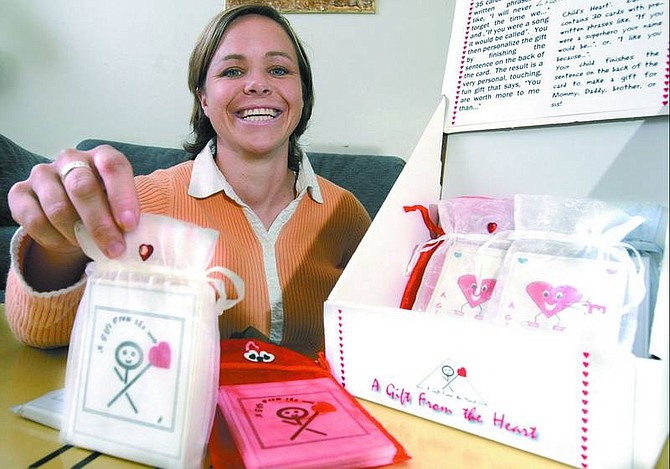 Chad Lundquist/Nevada Appeal Carson City entrepreneur Colleen Bannister, 32, shows the concept behind her &quot;A Gift from the Heart&quot; cards. Bannister started the business so she  could stay at home with her 19-month-old son.