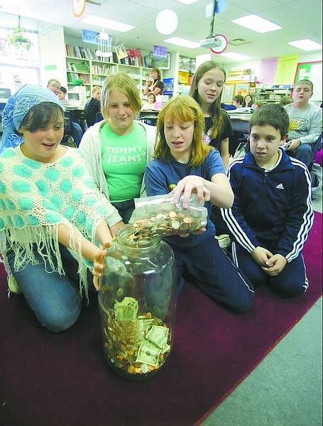 BRAD HORN/Nevada Appeal Fremont Elementary School fifth-grade students from left, Caitlyn Callahan, 11, Kalee Young, 11, Ashlee Salsbury, 11, Crystal Crites, 11, and Dartanyan Perry, 10, pour change into a jug in Lori Browning&#039;s math class at the school on Thursday. The money raised will be donated to the kids who were allegedly locked in a bathroom for several years and starved by their family.