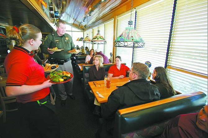 Brad horn/Nevada appeal Carson City Sheriff&#039;s Deputy Don White helps Applebee&#039;s server Jennifer Phillips deliver food to Elizabeth Self, center, and Amber Elkjer, right, during the Tip-A-Cop Special Olympics fundraiser Wednesday.