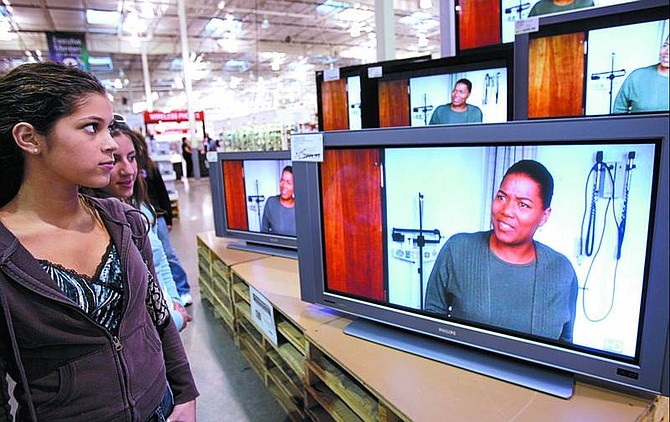 Photos by Chad Lundquist/Nevada Appeal Sarah Flores, 17, and Michelle Artinian, 18, both of South Lake Tahoe, look at a bank of high-definition TVs while shopping at the Carson City Costco on Wednesday.