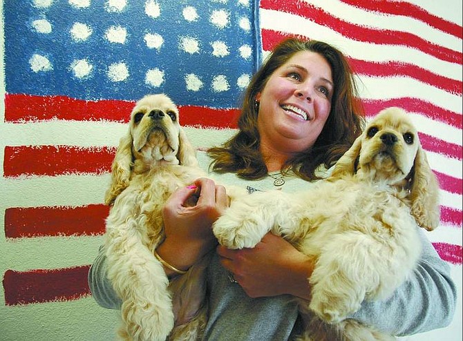 Kevin Clifford/Nevada Appeal Owner of All American Dog Grooming Tori McBride holds Nicky, left, and Paris Hilton, the daughters of her award-winning American cocker spaniel Polo at her shop. Polo will retire after going to the Westminster Kennel Club in New York next week while her puppies will start their dog show careers in two months.