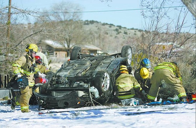 Cathleen Allison/Nevada Appeal Carson City firefighters work on two accident victims on Deer Run Road on Thursday morning. Both were pronounced dead at the scene.