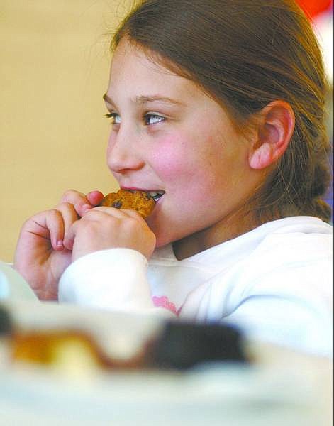 BRAD HORN/Nevada Appeal Sierra Scroggins, 8, of Carson CIty, enjoys a chocolate chip cookie at the Feast of Chocolate at the State Library and Archives on Saturday morning.