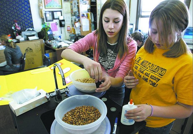 Cathleen Allison/ Nevada Appeal Geri Martini, 14, left, and Amanda Patterson, 13, prepare a science fair activity Wednesday morning at Virginia City Middle School. The annual Storey County Science Fair will be held tonight from 5:30-8 p.m. at the school gym.