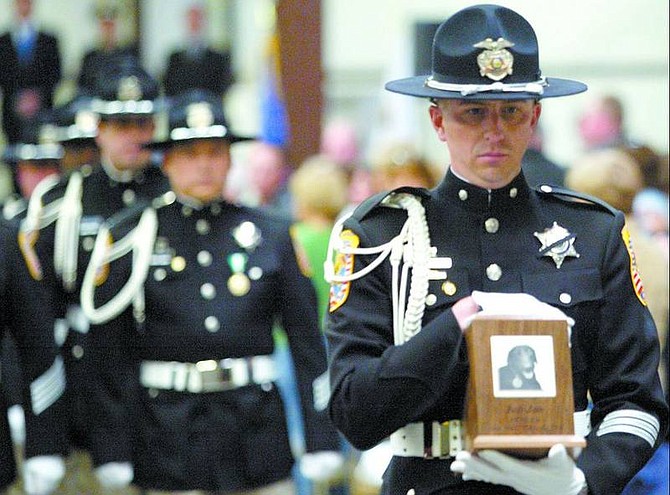 Shannon Litz/Nevada Appeal News Service Will Lynch, with the Douglas County Sheriff&#039;s Office Honor Guard, carries Jon-Jon&#039;s ashes out of the building following the memorial service at the Douglas County Fairgrounds Friday.