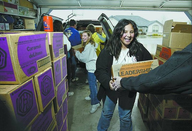 Girl Scouts Yesina Hua, right, and Melissa James, both 12, help load boxes of Girl Scout cookies into a  car. On  Monday, 24,000 boxes arrived for distribution in the Carson City area, beginning this  weekend.  Kurt Molnar/ Nevada Appeal