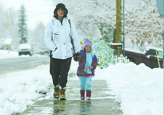 BRAD HORN/Nevada Appeal Sue Matuska and her daughter Emily, 4, of Carson City, walk home through the fresh snow after dropping a car off for repairs Friday morning.