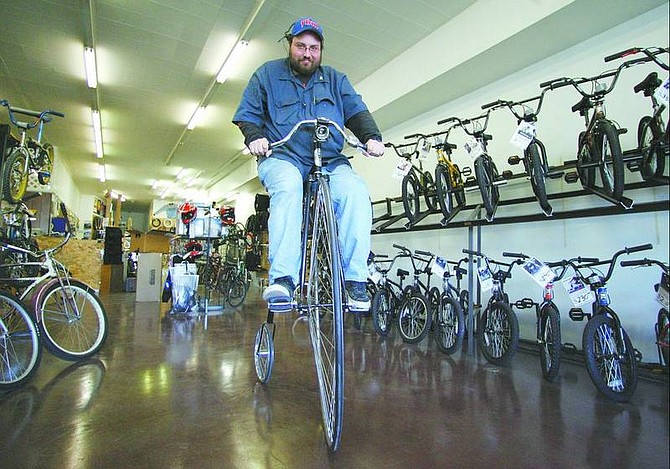 BRAD HORN/Nevada Appeal Dan Turner, owner of Bicycle Authority in Carson CIty, rides a Highwheeler bicycle at his shop on Thursday.
