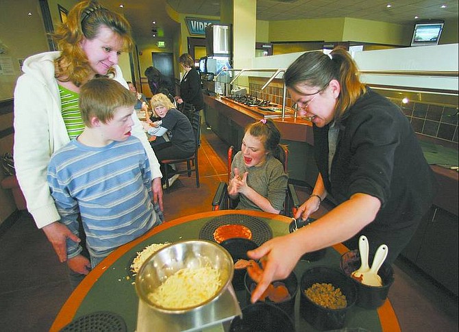 Micah Simon, left, and Aubrie Robards make pizzas Thursday.