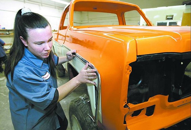 Cathleen Allison/Nevada Appeal Jasmin Feliciano fits a piece of trim Wednesday at the Desert Motor Sports Paint and Body Shop in Mound House.