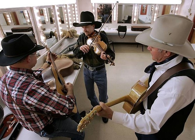 Chad Lundquist/Nevada Appeal Rush Creek band members Randy Pollard, center, Charlie Edsall, left, and John McLain, right, practice backstage on Saturday. The band was the closing act for the 12th annual Cowboy Jubilee and Poetry event held at the Carson City Community Center.