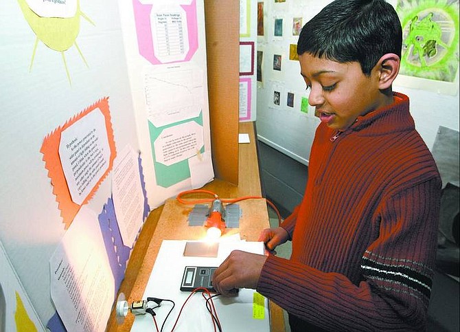 Cathleen Allison/Nevada Appeal Fritsch Elementary School fifth-grader Shashank Kandhadai, 10, explains his science project Wednesday night. Winners were recognized in a district-wide awards ceremony at Western Nevada Community College. Kandhadai won a first place award for his effort to see if the angle of a solar panel would effect the amount of power it produced.