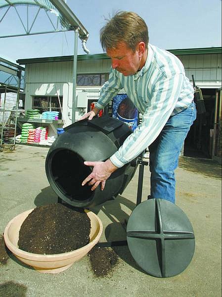 BRAD HORN/Nevada Appeal Dave Ruf, owner of the Greenhouse Garden Center, demonstrates the use of a compost barrel at his store.