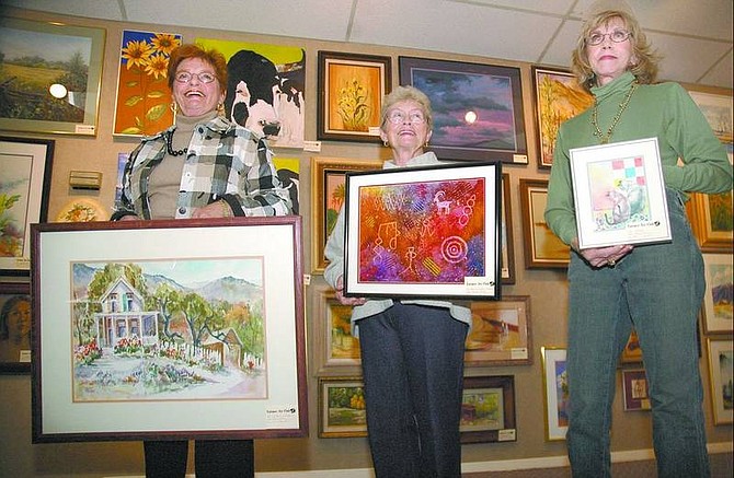 Kevin Clifford/Nevada Appeal Latimer Art Club member Pat Holub, 82, left, president Aleta Hursh, 73, and member Peggy Fowler, 75, show their paintings at the Brewery Arts Center on Friday evening. The club&#039;s work will be on display through April 6.
