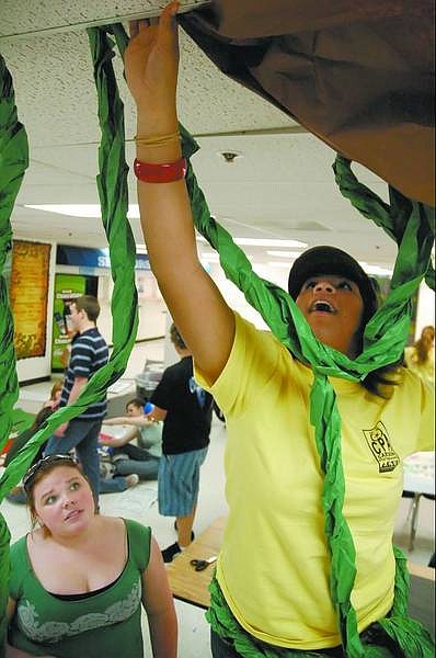 Kevin Clifford/Nevada Appeal Student council members Elia Bell, 18, left, and Kendra Jones, 17, hang paper vines on the ceiling Friday afternoon at Carson High School for the leadership conference.