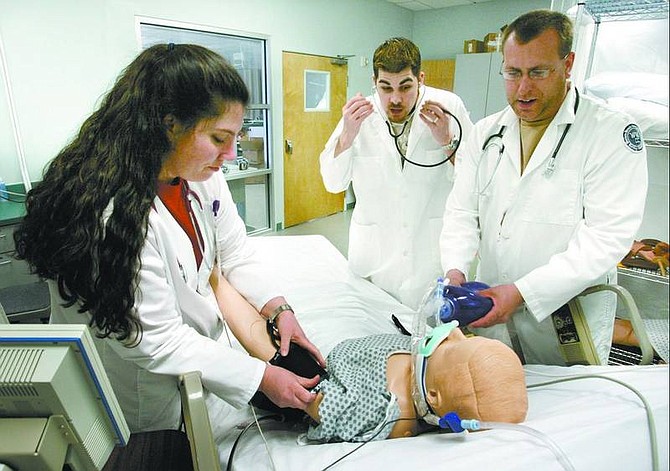 Cathleen Allison/Nevada Appeal Western Nevada Community College nursing students, from left, Cinnamon Martin, Kevin Moyamckay and Jason Kattenhorn, work on a simulation mannequin Thursday afternoon at the Carson City campus. A retired Carson City couple has donated $60,000 to purchase more equipment for the nursing program, including a new infant mannequin. The simulation mannequins allow instructors to provide real-life scenarios for more hands-on training.