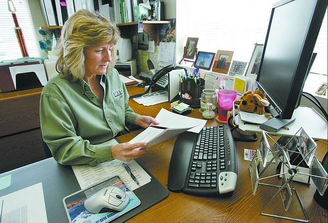 Cathleen Allison/Nevada Appeal Lynn Mackay, office manager for Metcalf Builders Inc., reads through registration paperwork from a federal Web site that will allow her to check the immigration status of new employees.