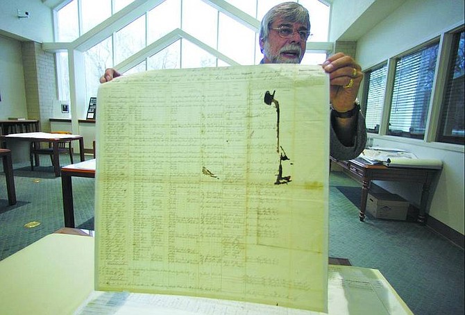BRAD HORN/Nevada Appeal State Archives Manager Jeff Kintop displays a Nevada Civil War Army Muster Roll in the archive room of the library on Wednesday.