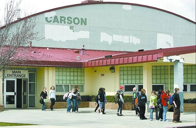Cathleen Allison/Nevada Appeal Students line up Wednesday afternoon beneath the Carson Middle School sign, which was defaced by vandals in a series of graffiti attacks in recent weeks. A Carson High School student was arrested and at least two other teens have been implicated.