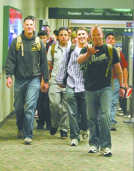 BRAD HORN/Nevada Appeal Marines in the Fourth Force Recon Reserves, including Lance Cpl. Matthew Martin, gesturing, walk down the concourse toward their families at the Reno-Tahoe International Airport after returning from Iraq on Monday.
