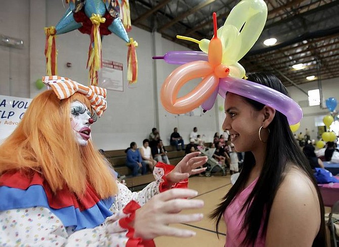 Chad Lundquist/Nevada Appeal Left, Bubbles the Clown talks with Ana Sanchez, 14, of Carson City, Sunday during the Dia Del Ni&#241;o celebration at the Carson City Community Center.