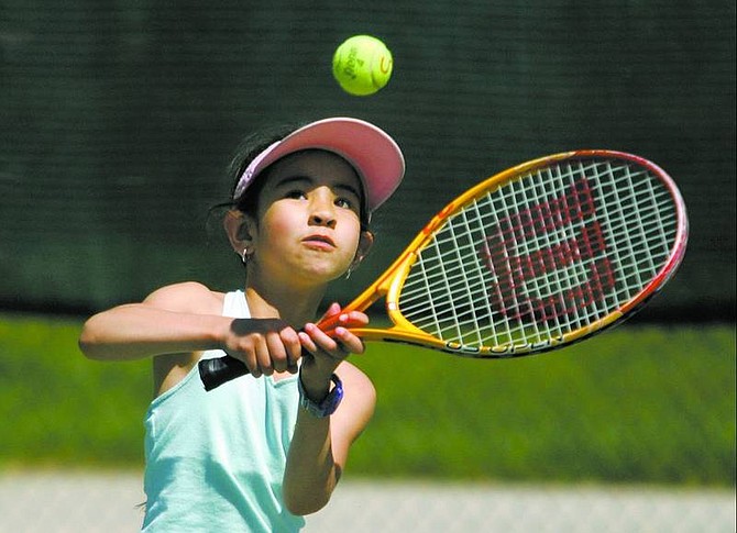 Shaylin Segura, 7, returns the ball her 9-year-old sister, Jesalea, hit while they were practicing tennis at JohnD Winters Centennial Park on Wednesday afternoon. The park was chosen as a potential site for a recreation center.  BRAD HORN Nevada Appeal