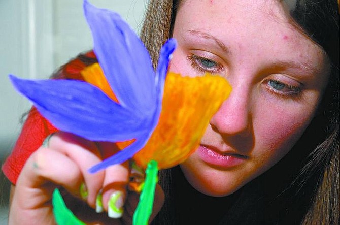 Kevin Clifford/Nevada Appeal Carson City High School senior Kimberly Zink, 17, shows off her artistic talent by painting a surrealist flower on plexiglass in her home Friday afternoon. Zink did her senior project on surrealist art and she received an &quot;A.&quot;