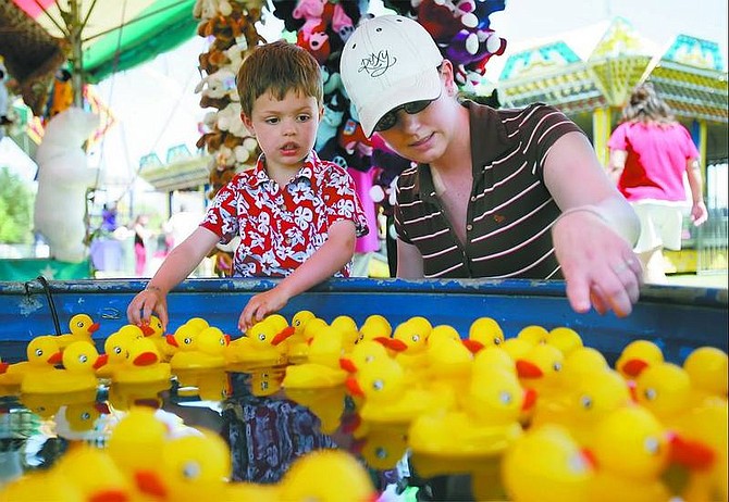 Jami Hawkins helps her son, Justin, pick a prize-winning duck Sunday at the Spring Fun Carnival in Mills Park. The Hawkins family has made it a tradition to go to the carnival on Mother&#039;s Day.   Chad Lundquist/ Nevada Appeal
