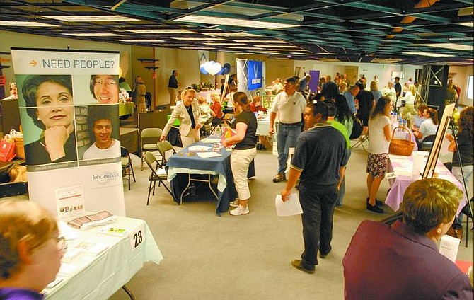 Kevin Clifford/Nevada Appeal People wander through the 33 booths Saturday morning comprising the annual Spring Job Fair, which was held at the Nevada Appeal.