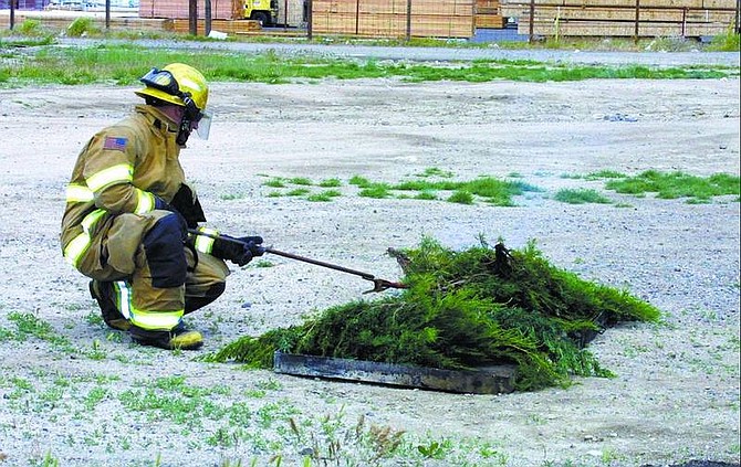 Terri Harber/Nevada Appeal  Carson City firefighter Dan Gelbman tries to light pieces of juniper bush during a fire-prevention demonstration Monday to mark Nevada Wildland Fire Awareness Week, which ends Friday.