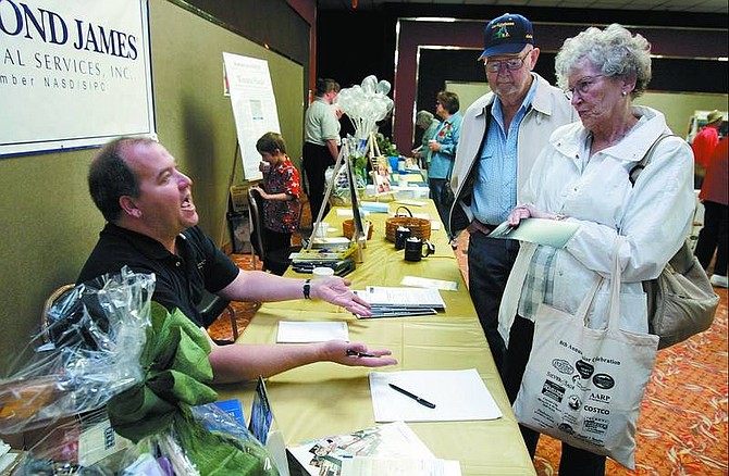 Daniel Bowler, left, financial adviser for Raymond James Financial Services, talks with Caroline Mauldin, 71, and Roy Swayze, 76 at the Senior Celebration Monday. The free annual event is sponsored by the Senior  Service Network.  Chad Lundquist/Nevada Appeal