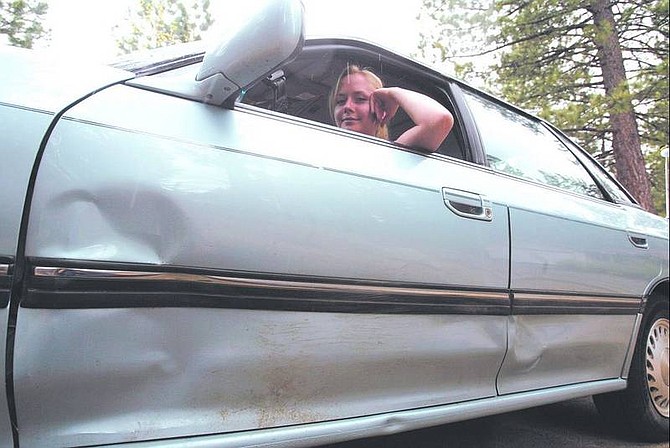 Dan Thrift/Appeal News Service Cassy Smith, 16, is shown in her 1992 Subaru Legacy, which was damaged when she collided with a bear last week.