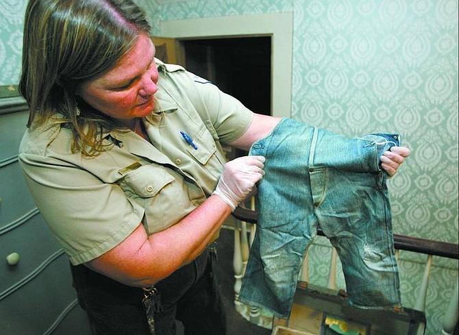 photos by Cathleen Allison/nevada appeal Suzanne Sturtevant, a supervisor with the Nevada Division of State Parks, holds a pair of overalls more than 100 years old that belonged to Dwight Dangberg, who died at age 6. Sturtevant toured the Dangberg Home Ranch in Minden May 12, describing the effort to sort and catalog the more than 18,000 items still in the historic home.