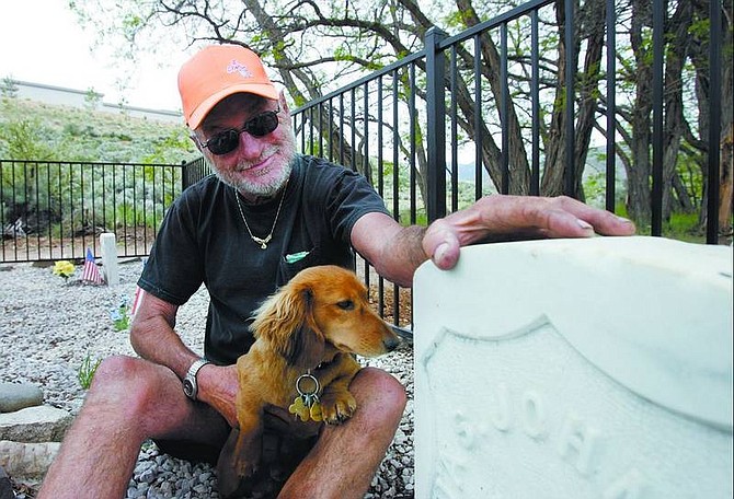 Chad Lundquist/Nevada Appeal Ron Mason and his dog Bodie sit near the graves of two civil war veterans in Fuji Park. The men were buried near the old Ormsby County Poor Farm where they stayed until their deaths. Mason has volunteered his time and money to maintain the area surrounding the graves for the last 18 months.