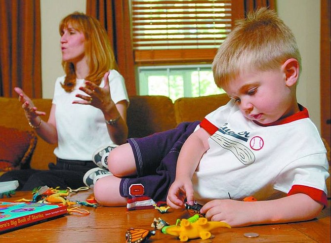 DAVID HOBBY/The Baltimore Sun Nicholas Salter, 3, plays with his toys at home as his mother, Jackie, discusses his sleep apnea. Nicholas had his tonsils removed in March, an operation that is making a rebound as a treatment for sleep apnea in children.