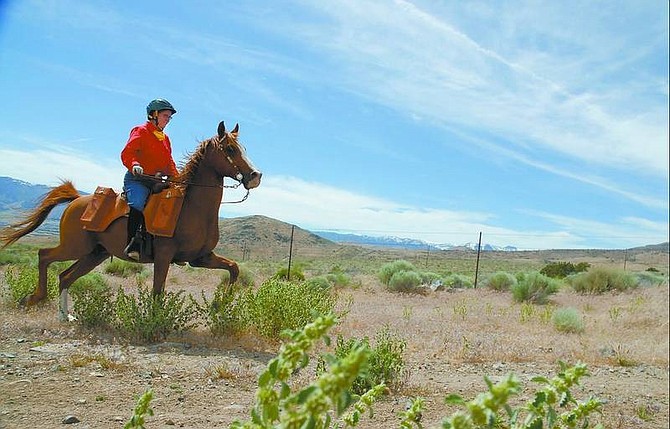 Kevin Clifford/Nevada Appeal  Pony Express rider Debbie Royer rides east near Highway 50, carrying the mochila to the next stop Wednesday afternoon. The Pony Express re-ride consists of 1,966 miles and ends June 16 in St. Joseph, Mo.