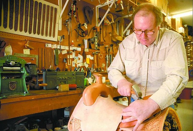 Kevin Clifford/Nevada Appeal Pete Schuler, saddle maker for the Hitchin&#039; Post Western Store in Carson City, cantle binds a show saddle. Schuler said he plans to continue leather work after the store&#039;s closure in August.