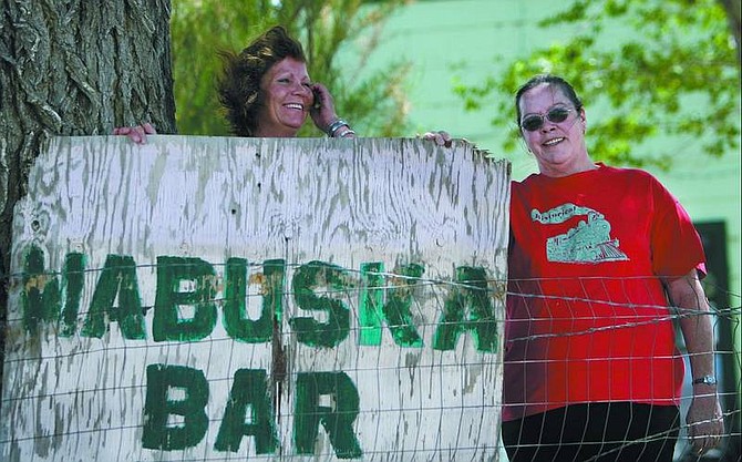 Chad Lundquist/Nevada Appeal Bartender Val Pearson and owner Linda Miller of Linda&#039;s Old Wabuska Bar stand in front of one of the bar&#039;s signs.