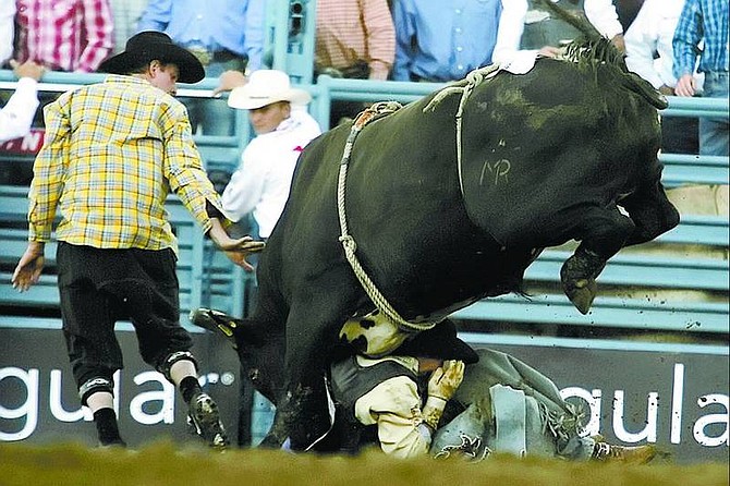 BRAD HORN/Nevada Appeal Jason McClain, of Lewis, Colo., gets stuck under Black Dancer during the Dodge Xtreme Bulls 2006 Hard Ride Tour on Thursday, June 15, 2006, at the outdoor arena at the Reno Livestock and Events Center in Reno, Nev.